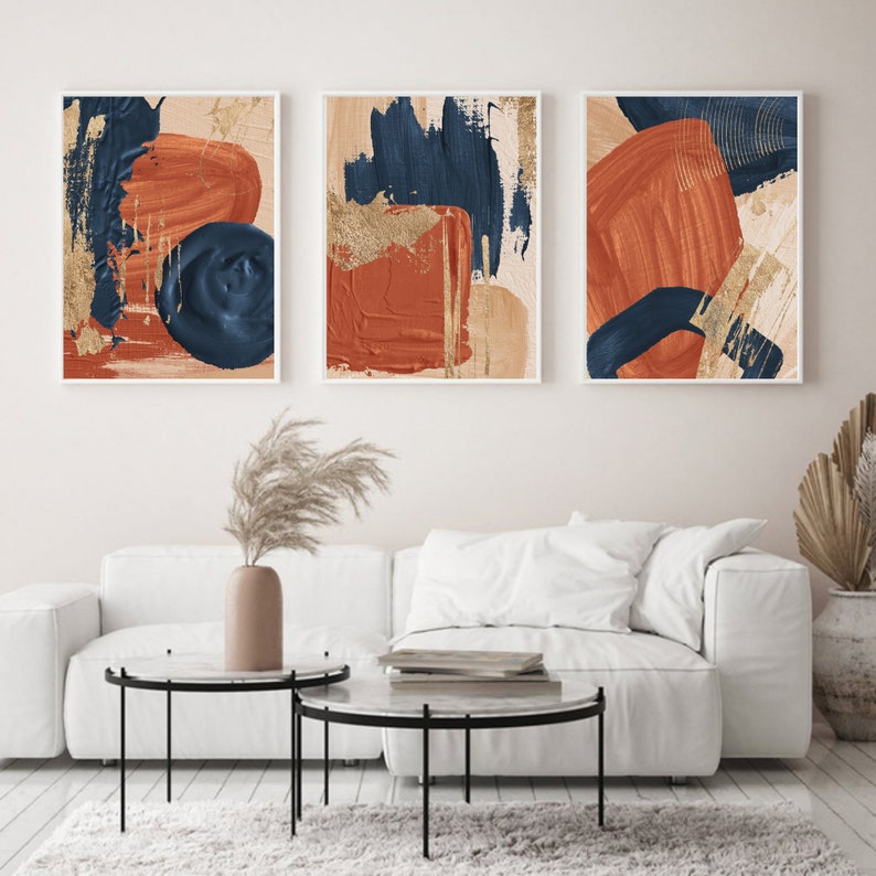 May include: Three abstract art prints with a white background and bold brushstrokes in shades of blue, orange, and gold.