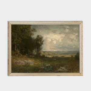 May include: A framed landscape painting depicting a rural scene with a cloudy sky, green trees, and a distant field. The painting is in a light wood frame.