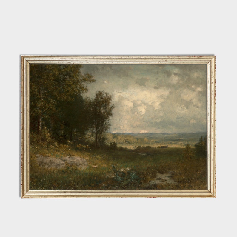 May include: A framed landscape painting depicting a rural scene with a cloudy sky, green trees, and a distant field. The painting is in a light wood frame.