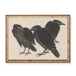 May include: A framed black and white print of three crows in a silhouette style. The crows are perched on a branch and are facing different directions. The print is set against a cream background.