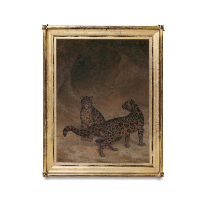 May include: A framed oil painting depicting two leopards in a dark cave setting. The leopards are brown and black with spots. The painting is set against a dark brown background.