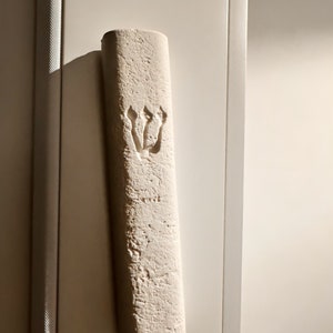 Może przedstawiać: Biała mezuza z rzeźbionym w reliefie wzorem Gwiazdy Dawida.