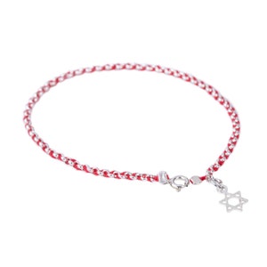 Puede incluir: Un brazalete de cuerda roja con una cadena de plata y un dije de plata en forma de Estrella de David.