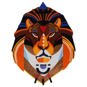 Peut inclure: Patch brodé représentant une tête de lion géométrique avec des couleurs orange, marron, noir, bleu, blanc et rouge. Le lion a un design géométrique avec un triangle sur son front et un point blanc sur son nez.
