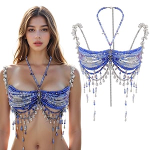 May include: A blue, white, and silver beaded top. The top has a halter neck and shoulder straps, with dangling beaded details. The design is intricate and detailed, with a focus on the texture and colour of the beads. A unique piece of body jewelry.