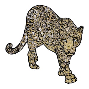 Op de afbeelding: Een gouden en zwarte pailletten strijk-op patch van een luipaard. De luipaard kijkt naar de rechterkant van de afbeelding en loopt met zijn hoofd hoog.