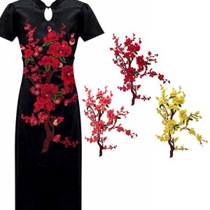 May include: Three embroidered floral appliques in red, pink, and yellow. Each applique features a stylised tree with delicate branches and blossoms.
