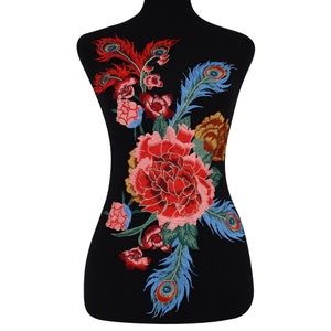 Puede incluir: Aplique bordado con una gran flor de peonía roja con hojas verdes y dos plumas de pavo real. Las plumas son azules, verdes y doradas con detalles de ojos.