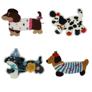 Op de afbeelding: Vier geborduurde vilt dachshund hond patches. De patches zijn in verschillende kleuren en ontwerpen, waaronder bruin en wit met roze stippen, zwart en wit met zwarte vlekken, grijs en blauw met gele bloemen en bruin en wit met blauwe strepen.