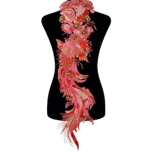 May include: Red and gold embroidered applique featuring a phoenix with a long tail of feathers. The applique is on a black background.