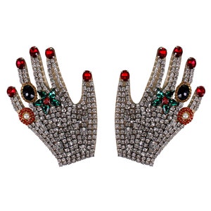 May include: A pair of jeweled hands with red, green, and black rhinestones. The hands are covered in clear rhinestones.