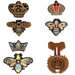 May include: Six embroidered patches featuring a crown, a bee, and a wreath with a crown. The patches are all gold and black with various colored accents.