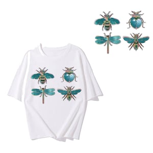 Puede incluir: Seis parches para planchar con insectos bordados. Los parches son verdes, azules y dorados. Los insectos incluyen una abeja, una mariquita y una libélula.