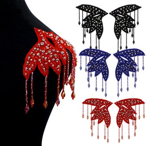 May include: Four pairs of red, black, and blue jeweled fabric appliques with dangling beads. The appliques are shaped like stylized leaves with a pointed tip.