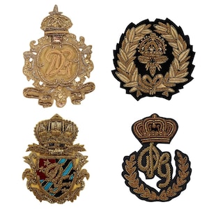 May include: Four embroidered patches featuring gold thread and black fabric. The patches depict a crown, a wreath, a shield, and a monogram.