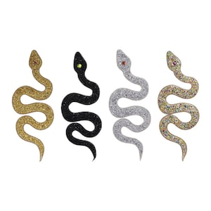 May include: Four sparkly snake-shaped patches in gold, silver, black, and iridescent colours. Each patch has a single rhinestone eye.