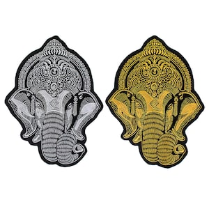 Op de afbeelding: Twee geborduurde patches van de hindoe-god Ganesha, een in zilver en een in goud, op een zwarte achtergrond.