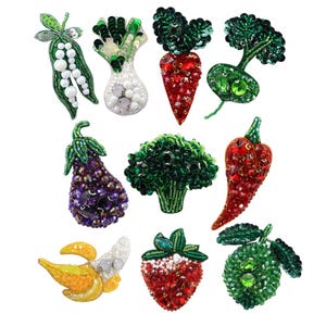 Puede incluir: Colección de broches de verduras y frutas con cuentas. Incluye una vaina de guisantes verdes, una cebolla blanca, una zanahoria roja, un rábano verde, una berenjena morada, un brócoli verde, un chile rojo, un plátano amarillo, una fresa roja y una manzana verde.