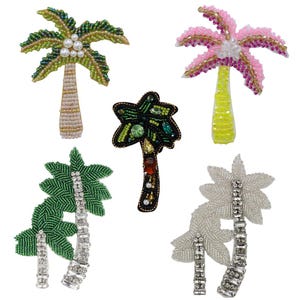 Può includere: Cinque diversi design di palme realizzati con perline e paillettes. Le palme sono di vari colori, tra cui verde, rosa, bianco e nero.