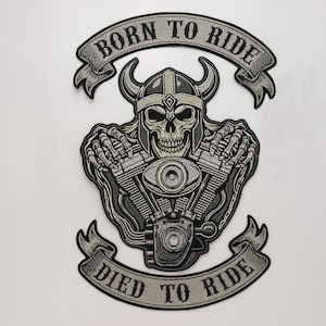 May include: An embroidered patch featuring a skull wearing a horned helmet, positioned above a motorcycle engine. The design includes two banners with the text BORN TO RIDE at the top and DIED TO RIDE at the bottom, rendered in black and grey thread.