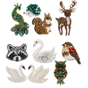 May include: A collection of beaded animal brooches, including a peacock, hedgehog, squirrel, deer, raccoon, swan, robin, and owl. The brooches feature various colors and textures, with intricate beadwork and embellishments.