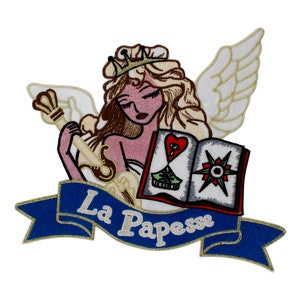 Può includere: Toppa ricamata con una donna con ali e una corona, che tiene una chiave e un libro con un cuore e una bussola. Il libro è aperto e il testo "La Papesse" è su un nastro blu.