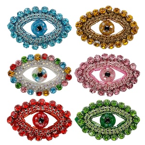 Può includere: Sei ciondoli portafortuna con occhio turco colorati con strass e perline. Ogni ciondolo ha la forma di un occhio con un centro di colore diverso. I ciondoli sono blu, oro, bianco, rosa, rosso e verde.