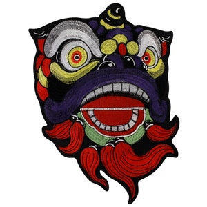 Puede incluir: Un parche bordado colorido que representa un disfraz de danza del león. La cara del león es morada, con acentos amarillos y rojos. El león tiene una boca grande abierta con labios rojos y una lengua verde. La melena del león es roja y negra.