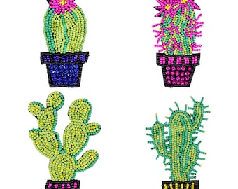 May include: Four colourful beaded cactus plants in pots. The cacti are green, yellow, and pink with black outlines. The pots are blue, pink, and yellow.