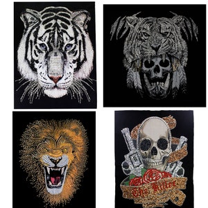 May include: Four iron-on patches featuring animal and skull designs. The first patch is a white tiger head. The second patch is a black and silver tiger head with a skull underneath. The third patch is a lion head with a roaring expression. The fourth patch is a skull with two pistols and a rose.