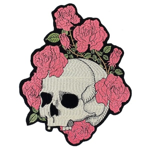 May include: Embroidered patch featuring a white skull with a pink rose crown. The skull has detailed features and is surrounded by pink roses with green leaves.