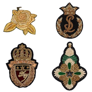 May include: Four embroidered patches with gold, black, and green thread. The patches feature a rose, a crown with an initial, a crest with a crown and the text "LOVE CREATIVE" and a star, and a cross with a star.