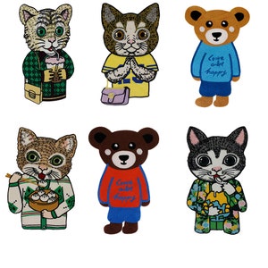 Peut inclure: Six patchs brodés représentant des animaux de dessin animé. Les patchs comprennent un chat tenant une boisson, un chat avec un sac à main, un ours avec le texte "Love and be happy", un chat tenant des baguettes et des boulettes, un ours avec le texte "Love and be happy", et un chat tenant une sucette glacée.
