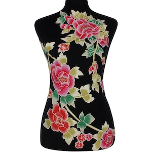 May include: A black fabric applique featuring a floral design. The embroidered flowers are in shades of red and pink, with green and yellow leaves. The applique is displayed on a black mannequin.