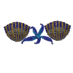 Könnte beinhalten: Zwei goldene und blaue Muscheln mit Juwelenbesatz und einem blauen, mit Juwelen besetzten Seestern in der Mitte.