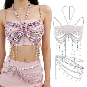 May include: A pink beaded top and matching skirt set. The top features a halter neck and shoulder straps, adorned with white, purple, and clear beads. The skirt has a beaded belt with a large silver ring. A second beaded top is also shown.