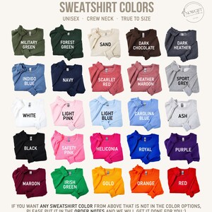 May include: A chart showing 24 different sweatshirt colors. The colors are arranged in a grid of six rows and four columns. The colors include military green, forest green, sand, dark chocolate, dark heather, indigo blue, navy, scarlet red, heather maroon, sport grey, white, light pink, light blue, Carolina blue, ash, black, safety pink, heliconia, royal, purple, maroon, Irish green, gold, orange, and red. The text "SWEATSHIRT COLORS" is at the top of the chart. The text "UNISEX - CREW NECK - TRUE TO SIZE" is below the title. The text "NOWGIFT" is in the upper right corner of the chart.