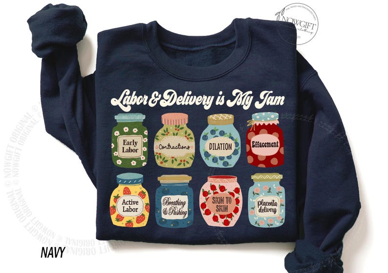 May include: Navy blue sweatshirt with a graphic of jars of jam, each labeled with a stage of labor and delivery. The text "Labor & Delivery is My Jam" is printed above the jars.
