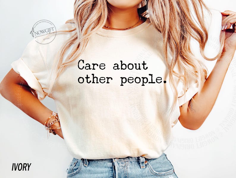 Puede incluir: Una camiseta blanca con el texto "Care about other people." impreso en negro. La camiseta la lleva puesta una persona con el pelo largo y rubio. El fondo es blanco.