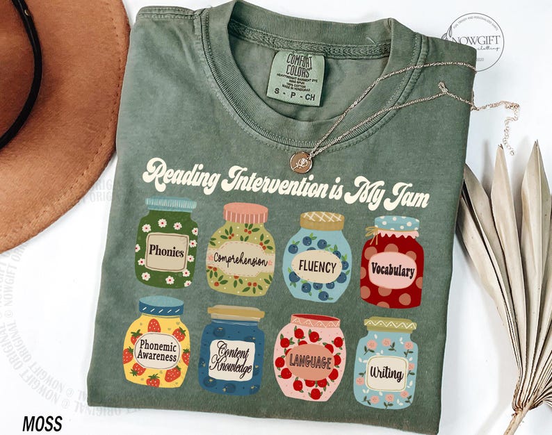 May include: Green t-shirt with the text "Reading Intervention is My Jam" and illustrations of jars with different reading skills, such as phonics, comprehension, fluency, vocabulary, phonemic awareness, content knowledge, language, and writing.
