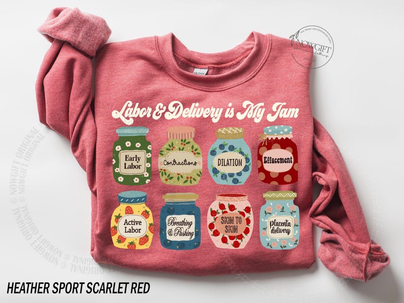 May include: A heather sport scarlet red sweatshirt with a graphic of jars of jam, each labeled with a stage of labor and delivery. The text "Labor & Delivery is My Jam" is printed in a retro font above the jars.