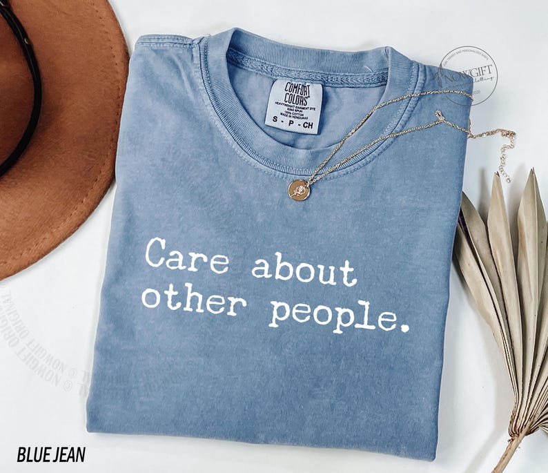 Puede incluir: Una camiseta azul jean con el texto "Care about other people." impreso en blanco.