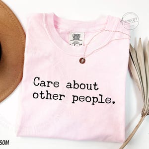 Puede incluir: Camiseta rosa con el texto "Care about other people." impreso en negro.