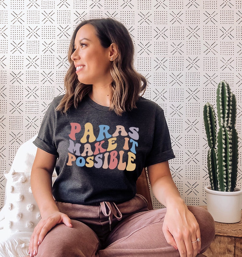 May include: A dark grey t-shirt with the text "Paras Make It Possible" in colorful, retro-style lettering.