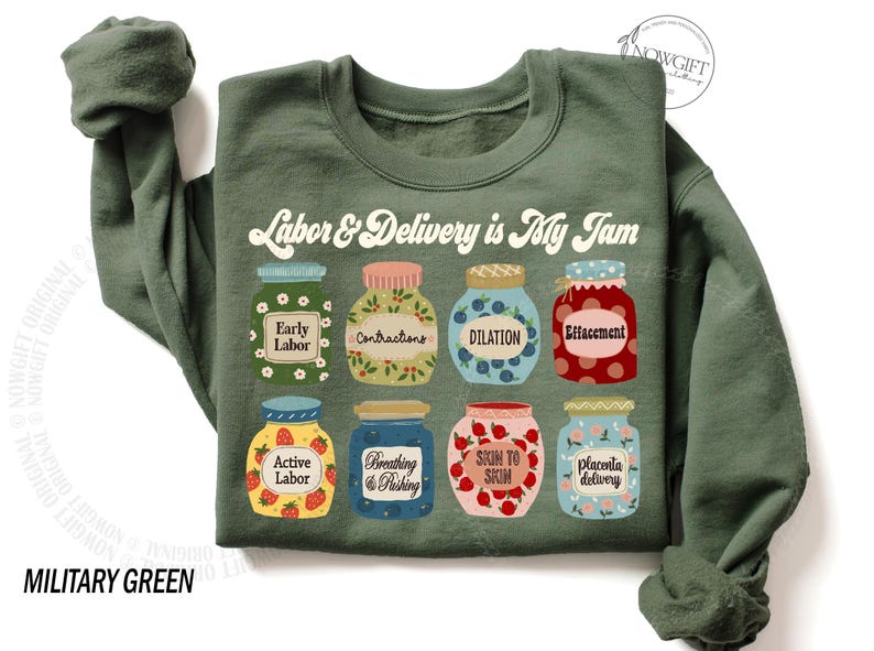 May include: A green sweatshirt with the text "Labor & Delivery is My Jam" in a retro font. The text is surrounded by nine illustrated jars of jam, each with a different label related to labor and delivery, such as "Early Labor", "Contractions", and "Effacement".