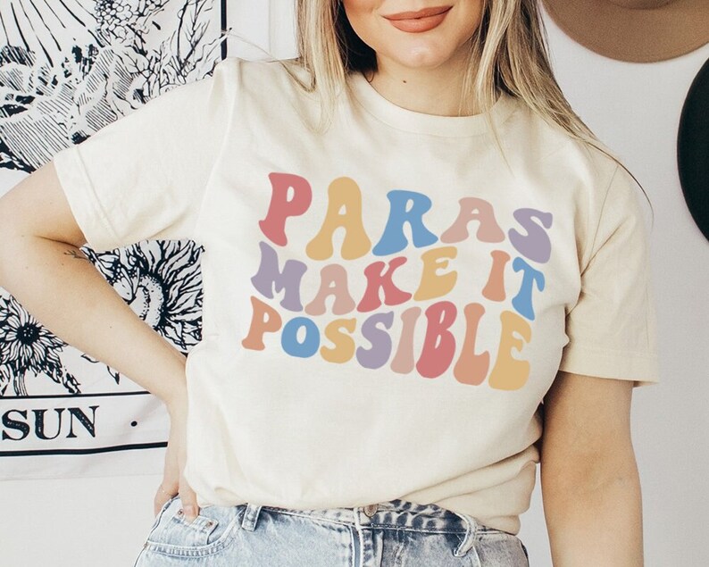 May include: A white t-shirt with the text "Paras Make It Possible" in rainbow-colored letters. The letters are in a retro font style.