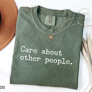 Puede incluir: Una camiseta verde con el texto "Care about other people." impreso en blanco.