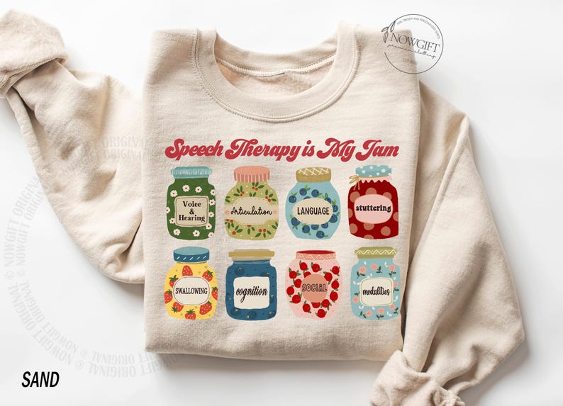 May include: A beige sweatshirt with the text "Speech Therapy is My Jam" in red and white. The text is surrounded by nine illustrated jars of jam, each with a different speech therapy topic written on the label.