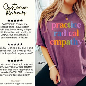 May include: Berry-colored t-shirt with the words "practice radical empathy" in colorful letters. The shirt has a crew neck and short sleeves. The image also includes customer reviews.