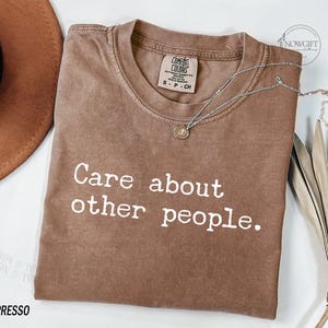Puede incluir: Una camiseta marr&oacute;n con el texto "Care about other people." impreso en blanco.